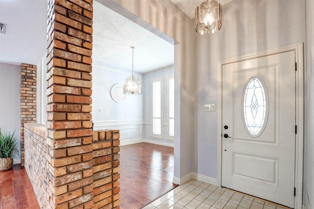 foyer featuring a chandelier, light wood-style flooring, and baseboards