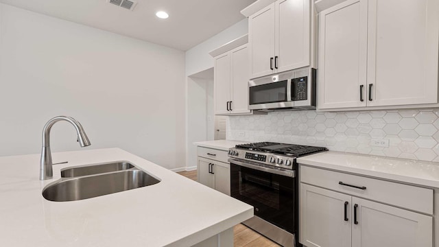 122 Palo Duro Bnd, Rhome, TX 76078 - kitchen featuring appliances with stainless steel finishes, light countertops, white cabinets, backsplash, and recessed lighting