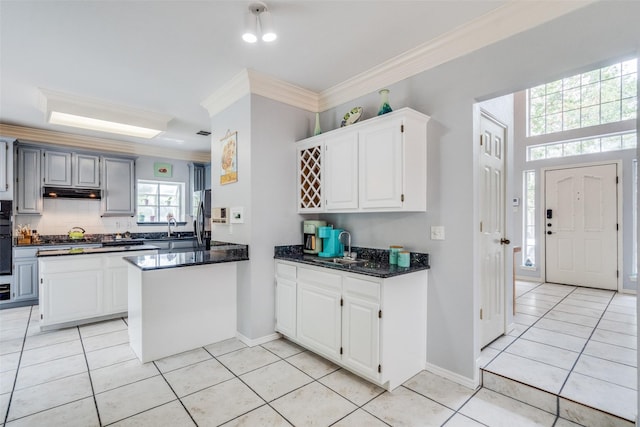 4219 Voss Hills Pl, Dallas, TX 75287 - kitchen featuring white cabinets, under cabinet range hood, decorative backsplash, light tile patterned flooring, and ornamental molding
