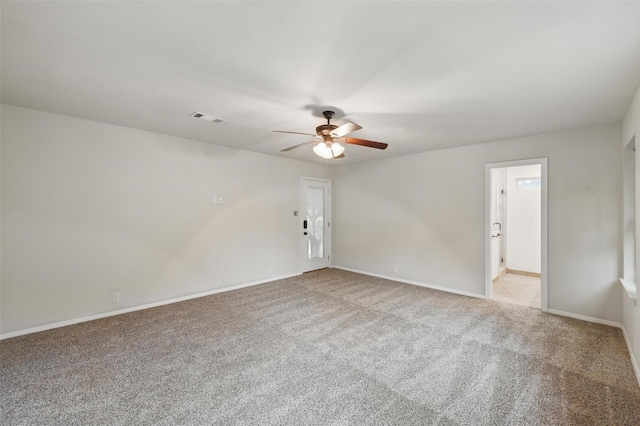 spare room featuring a ceiling fan, light colored carpet, and baseboards