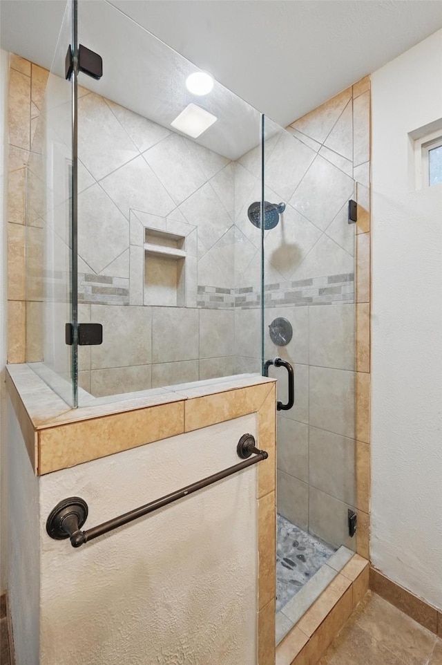 full bathroom featuring a shower stall and tile patterned flooring