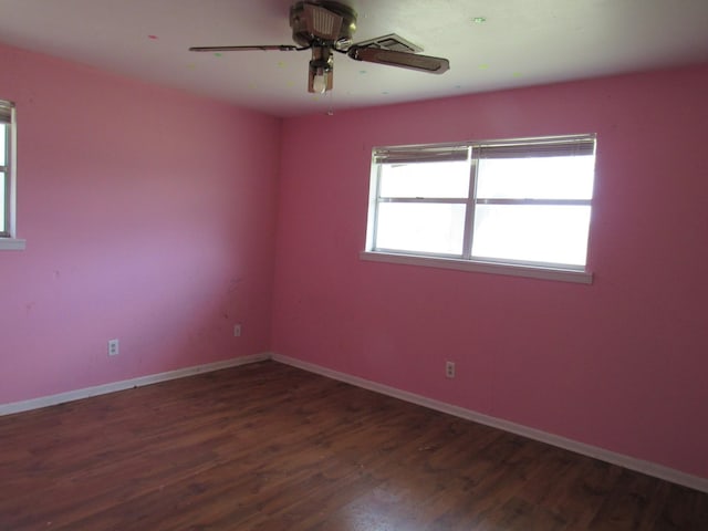 empty room with baseboards, wood finished floors, and a ceiling fan