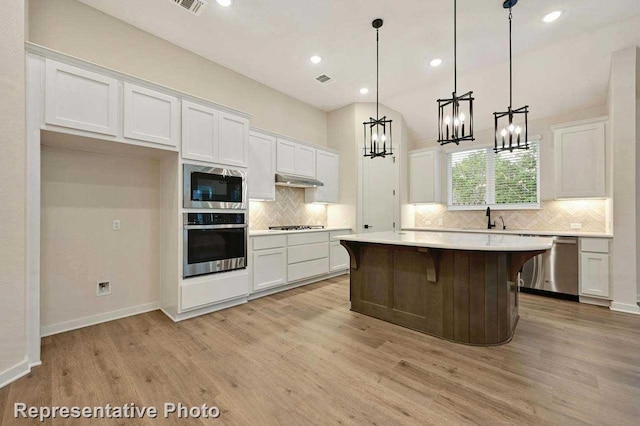 11745 Edgewood Dr, Justin, TX 76247 - kitchen featuring white cabinetry, backsplash, a chandelier, and appliances with stainless steel finishes