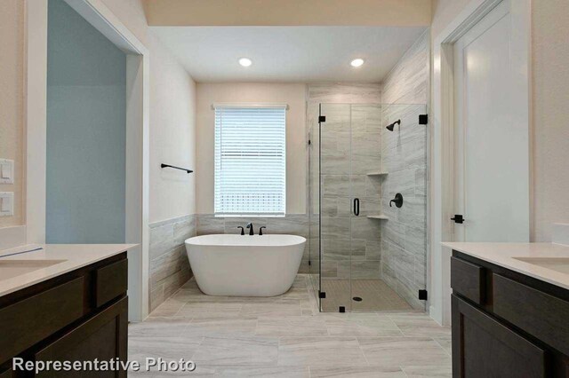 11745 Edgewood Dr, Justin, TX 76247 - bathroom with a stall shower, recessed lighting, a freestanding tub, and two vanities