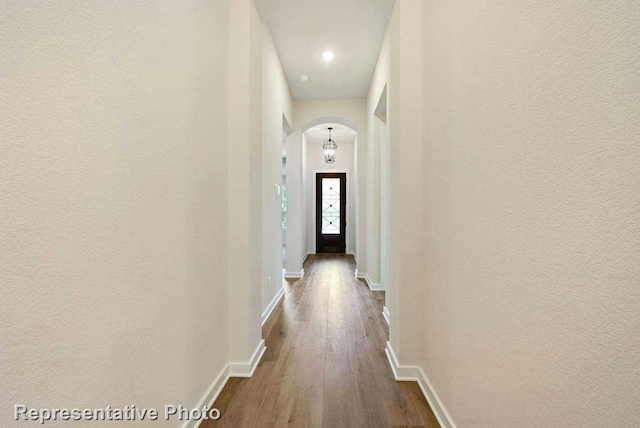 11745 Edgewood Dr, Justin, TX 76247 - corridor featuring dark wood-style flooring, a textured wall, arched walkways, and baseboards