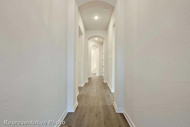 11745 Edgewood Dr, Justin, TX 76247 - corridor with dark wood-type flooring, baseboards, arched walkways, and a textured wall