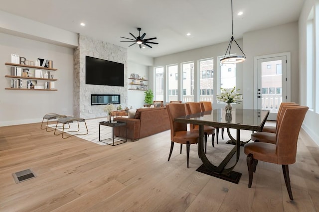 235 E Nash St Unit 118, Grapevine, TX 76051 - dining room with visible vents, baseboards, a stone fireplace, light wood-style floors, and recessed lighting