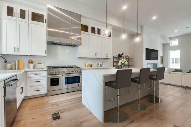 235 E Nash St Unit 118, Grapevine, TX 76051 - kitchen with a kitchen island, appliances with stainless steel finishes, visible vents, and light wood-style flooring