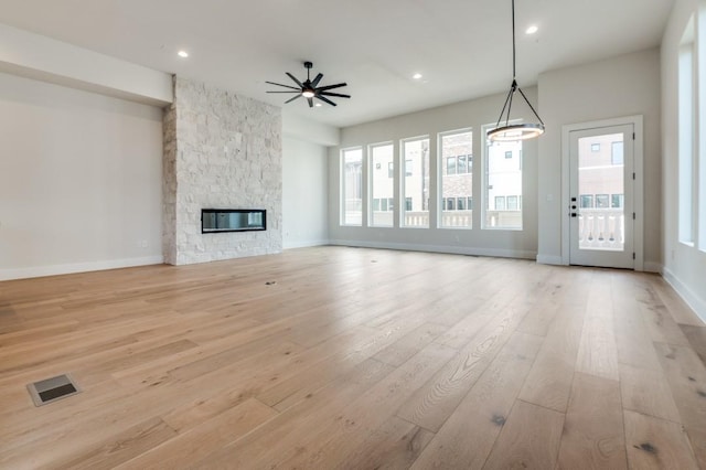 235 E Nash St Unit 118, Grapevine, TX 76051 - unfurnished living room featuring light wood-type flooring, baseboards, a fireplace, and visible vents