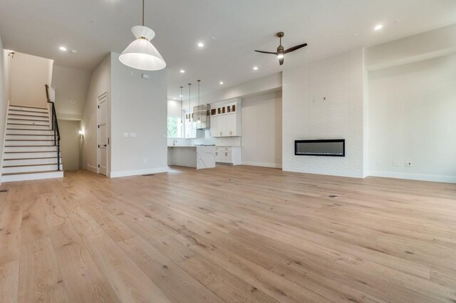 235 E Nash St Unit 118, Grapevine, TX 76051 - unfurnished living room featuring light wood-type flooring, baseboards, and ceiling fan