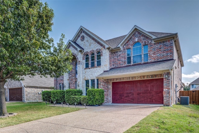 traditional home featuring central air condition unit, fence, an attached garage, driveway, and a front yard