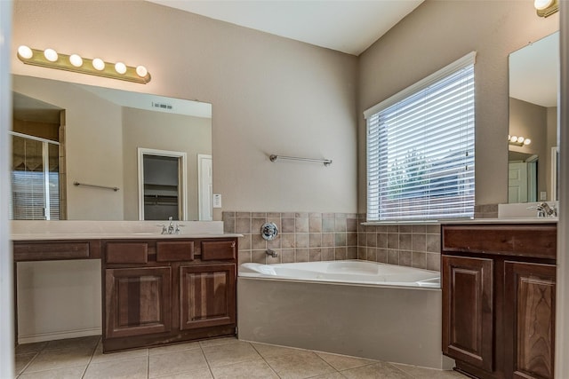 bathroom featuring two vanities, tile patterned floors, a garden tub, and visible vents