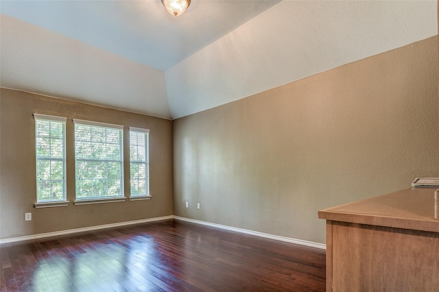 spare room with dark wood-type flooring and baseboards