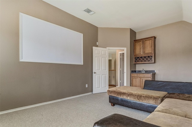 living area featuring baseboards, wet bar, visible vents, and carpet floors
