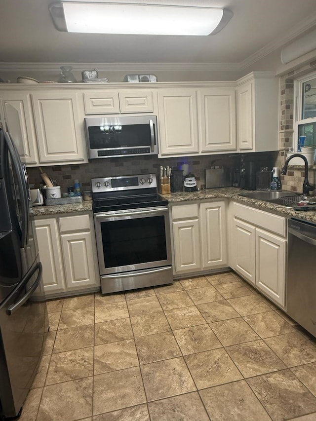 1104 County Road 701, Cleburne, TX 76031 - kitchen with a sink, crown molding, decorative backsplash, white cabinets, and appliances with stainless steel finishes