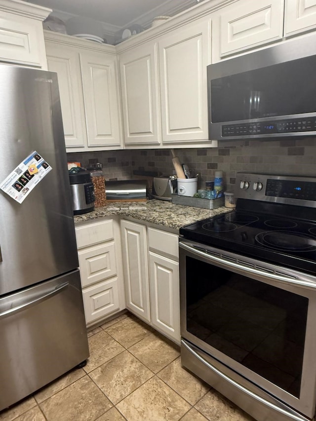 1104 County Road 701, Cleburne, TX 76031 - kitchen with light tile patterned floors, backsplash, stainless steel appliances, and white cabinetry