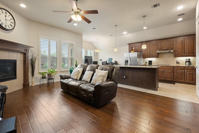 living area featuring vaulted ceiling, ceiling fan, hardwood / wood-style floors, and visible vents