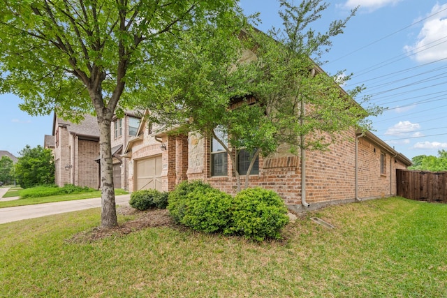 view of home's exterior with fence, brick siding, concrete driveway, a garage, and a lawn