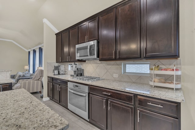 kitchen featuring open floor plan, appliances with stainless steel finishes, tasteful backsplash, lofted ceiling, and ornamental molding
