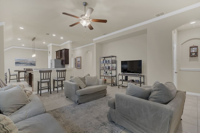 living area with arched walkways, light tile patterned floors, and ceiling fan