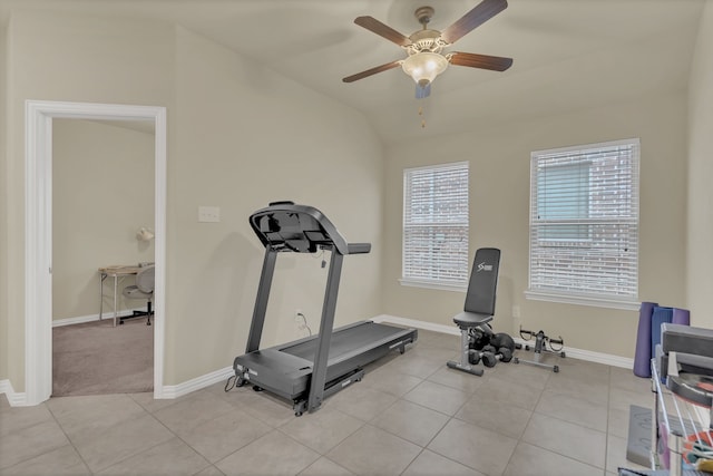 exercise room with a ceiling fan, baseboards, light tile patterned flooring, and vaulted ceiling