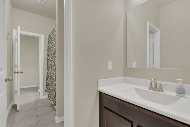 bathroom featuring baseboards, tile patterned flooring, and vanity