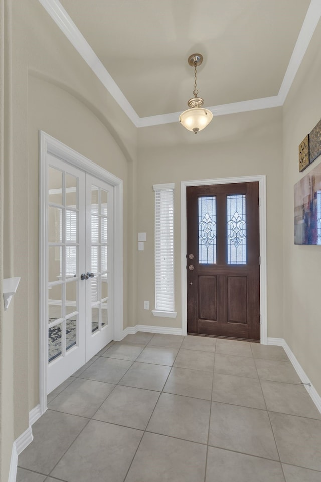 foyer entrance featuring baseboards, crown molding, french doors, and light tile patterned flooring