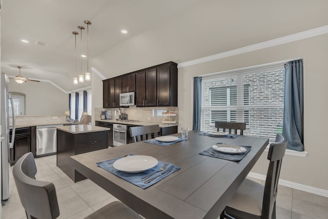 dining area featuring ceiling fan, crown molding, vaulted ceiling, and a healthy amount of sunlight