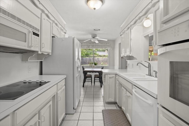 kitchen with white appliances, light tile patterned flooring, ceiling fan, a sink, and light countertops