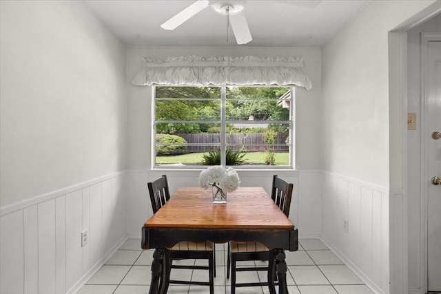 dining room featuring wainscoting, light tile patterned flooring, and ceiling fan