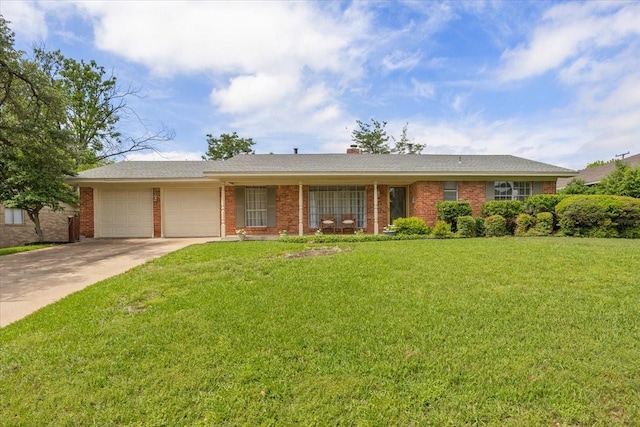 single story home featuring a chimney, driveway, brick siding, an attached garage, and a front lawn