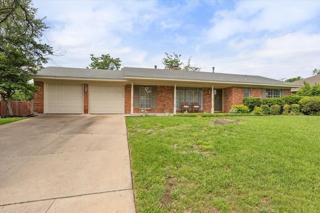 single story home with concrete driveway, a front lawn, brick siding, and a garage