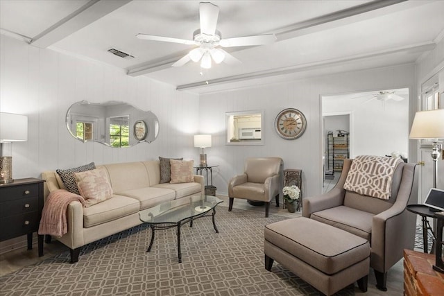 living area with beamed ceiling, visible vents, and ceiling fan