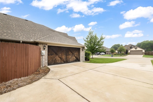 4037 Knightsbridge Ln, Midlothian, TX 76065 - view of side of property featuring an attached garage, fence, a shingled roof, concrete driveway, and brick siding