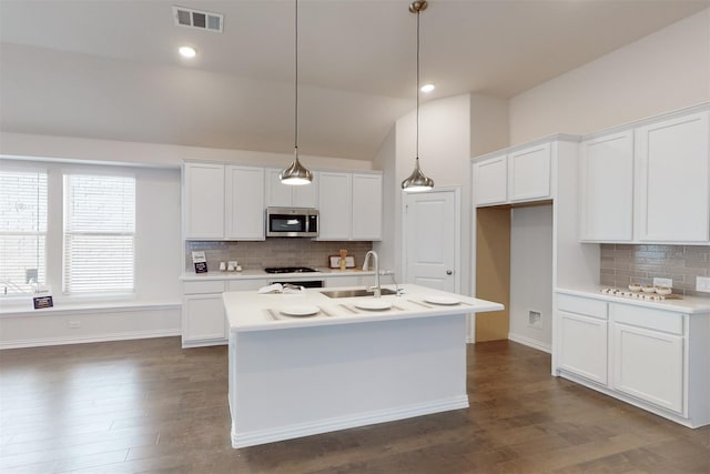 925 Plaza Ln, Argyle, TX 76226 - kitchen with a sink, visible vents, stainless steel microwave, decorative backsplash, and vaulted ceiling
