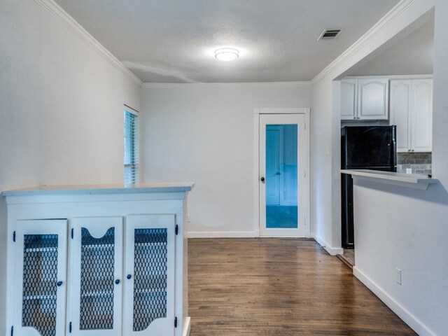 3703 Clover Ln, Dallas, TX 75220 - interior space featuring white cabinets, crown molding, dark wood-style flooring, baseboards, and light countertops