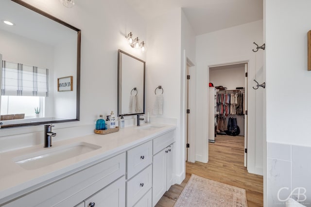 7001 Breezeway Dr, Abilene, TX 79606 - full bathroom with a sink, double vanity, a spacious closet, and wood finished floors