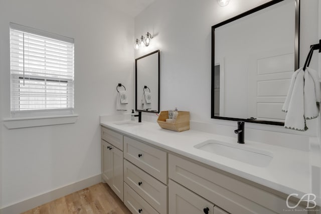 7001 Breezeway Dr, Abilene, TX 79606 - full bathroom with a sink, double vanity, baseboards, and wood finished floors