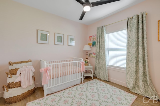 7001 Breezeway Dr, Abilene, TX 79606 - bedroom featuring a crib, wood finished floors, baseboards, and ceiling fan