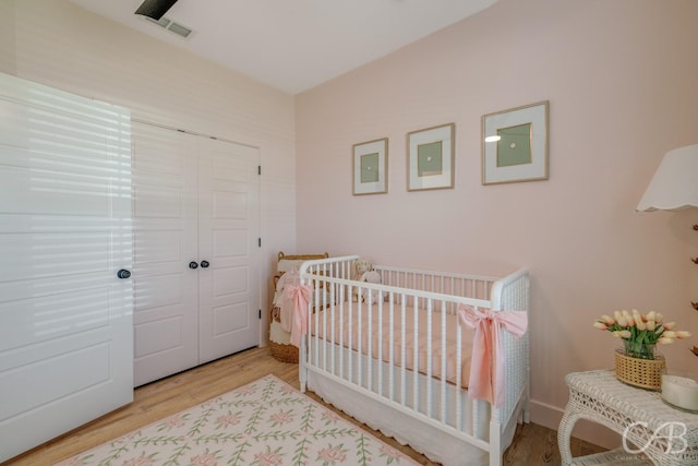 7001 Breezeway Dr, Abilene, TX 79606 - bedroom with a nursery area, a closet, visible vents, and wood finished floors