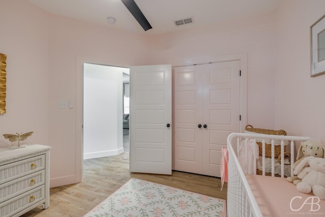 7001 Breezeway Dr, Abilene, TX 79606 - bedroom with a crib, light wood-style flooring, a closet, and visible vents