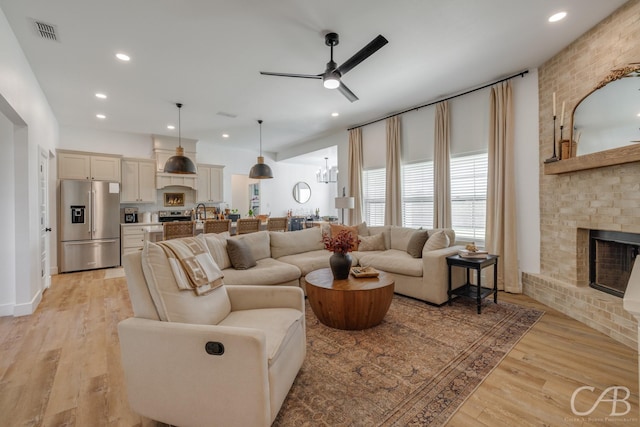 7001 Breezeway Dr, Abilene, TX 79606 - living area featuring ceiling fan, light wood-style floors, a fireplace, and visible vents