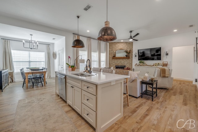 7001 Breezeway Dr, Abilene, TX 79606 - kitchen with ceiling fan with notable chandelier, a sink, visible vents, a large fireplace, and dishwasher