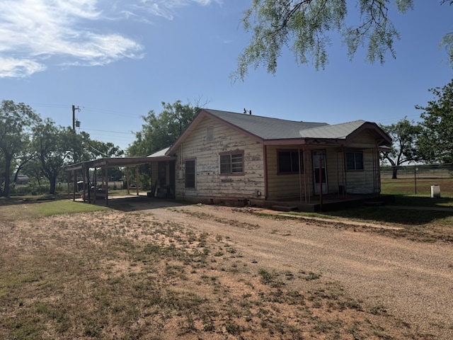 2466 Green St, Abilene, TX 79603 - view of property exterior featuring a carport, stone siding, and dirt driveway