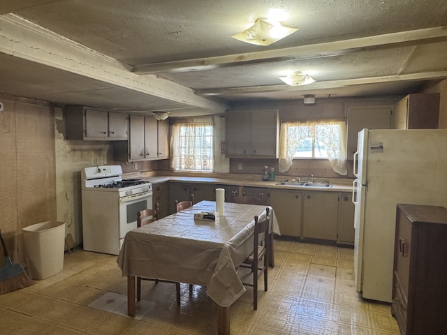 2466 Green St, Abilene, TX 79603 - kitchen featuring white appliances, plenty of natural light, a sink, light floors, and a textured ceiling