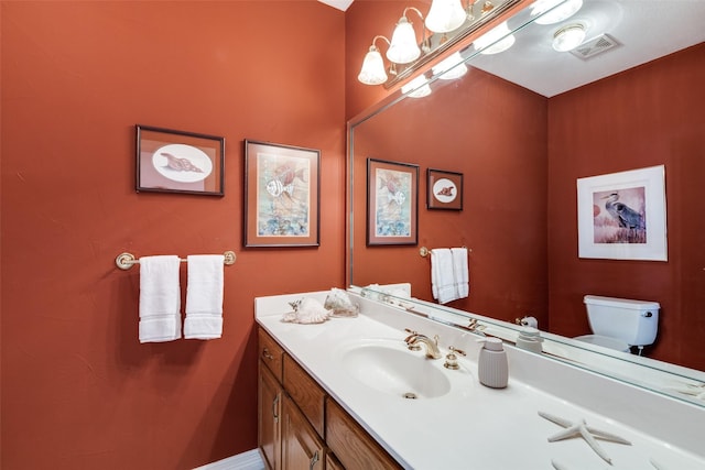 half bathroom featuring toilet, vanity, and a chandelier