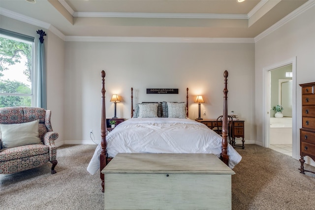 carpeted bedroom with a raised ceiling, ornamental molding, ensuite bath, and baseboards