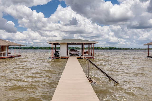 dock area with boat lift and a water view