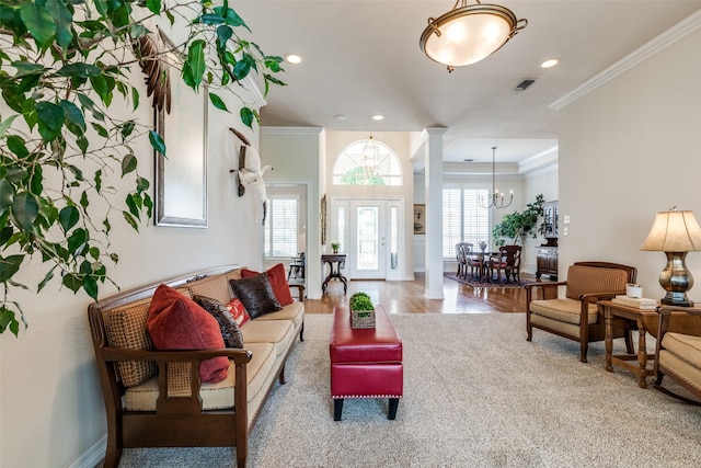 living room featuring a chandelier, wood finished floors, ornate columns, recessed lighting, and ornamental molding