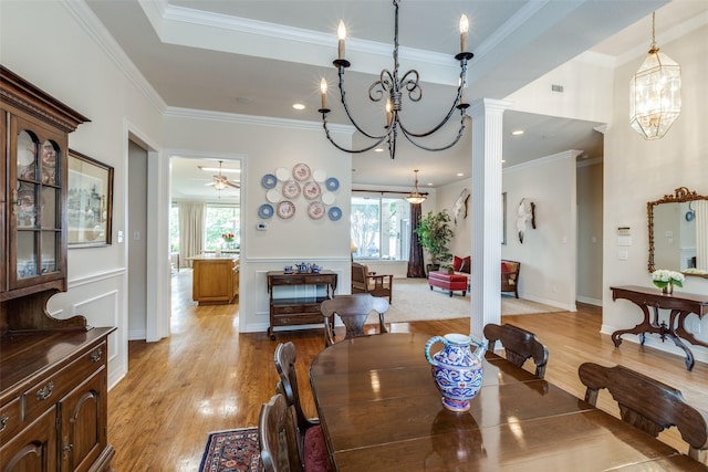 dining space featuring a chandelier, ornamental molding, light wood-type flooring, and ceiling fan